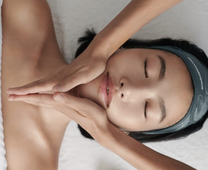 a woman lying down with her hands on her face